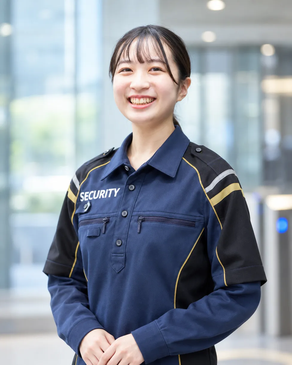 制服姿で笑顔で立つ女性スタッフ
